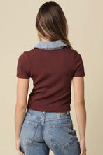 Load image into Gallery viewer, A woman viewed from behind wearing a short-sleeve ribbed knit top in burgundy with a light blue denim collar, paired with light-wash blue jeans, against a solid beige background.
