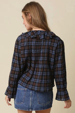 Load image into Gallery viewer, A woman shown from the back wearing a dark plaid long-sleeve blouse with a ruffled collar and flared cuffs, paired with a denim mini skirt, against a plain beige background.