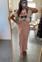 Load image into Gallery viewer, Person taking a mirror selfie wearing a graphic t-shirt and floral skirt in a room.