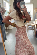 Load image into Gallery viewer, Person taking a mirror selfie wearing a white top and floral skirt in a store.