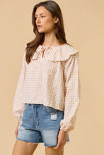 Load image into Gallery viewer, Woman wearing a checkered blouse and denim shorts on a beige background
