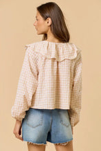 Load image into Gallery viewer, A woman shown from the back wearing a light beige and white gingham eyelet blouse with a wide ruffled collar and long sleeves, paired with denim shorts, against a solid beige background.