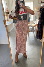 Load image into Gallery viewer, Person taking a mirror selfie wearing a graphic t-shirt and floral skirt in a clothing store.