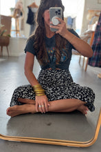 Load image into Gallery viewer, Person sitting on a mirror taking a selfie in a casual setting.
