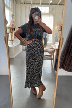 Load image into Gallery viewer, Person taking a mirror selfie wearing a floral skirt and crop top in a store.