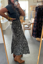 Load image into Gallery viewer, Person taking a mirror selfie wearing a black floral skirt and brown boots in a store.