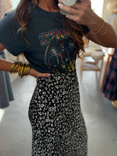 Load image into Gallery viewer, Person wearing a graphic t-shirt and floral skirt in an indoor setting