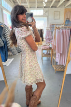 Load image into Gallery viewer, Woman taking a mirror selfie wearing a floral dress in a clothing store.