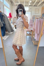 Load image into Gallery viewer, Woman taking a mirror selfie wearing a floral dress and brown boots in a clothing store.