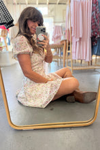 Load image into Gallery viewer, Woman taking a mirror selfie wearing a floral dress in a store.