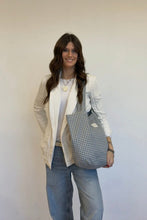 Load image into Gallery viewer, Woman holding a checkered bag against a plain background