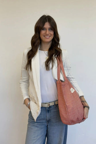 Woman holding a pink tote bag against a white background