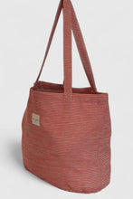 Load image into Gallery viewer, Striped tote bag with a visible brand label on a light gray background