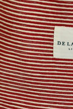 Load image into Gallery viewer, Close-up of red and white striped fabric with a brand label.