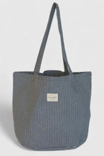 Load image into Gallery viewer, Striped tote bag with a visible brand label on a light gray background