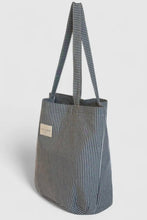 Load image into Gallery viewer, Striped tote bag with a visible brand label on a light gray background