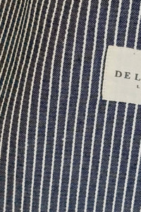 Close-up of a navy and white striped fabric with a label in the corner.