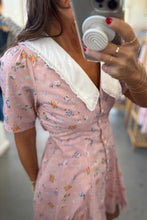 Load image into Gallery viewer, Person wearing a pink floral dress with white lace trim, taking a mirror selfie.