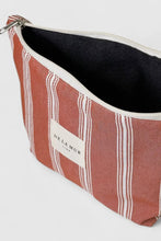 Load image into Gallery viewer, Striped fabric pouch with a visible brand label on a light gray background