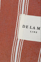 Load image into Gallery viewer, Close-up of red and white striped fabric with a Delamere Line label.