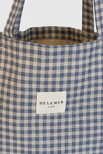Load image into Gallery viewer, Blue and beige checkered tote bag with &#39;De La Mub&#39; label on a white background