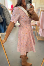 Load image into Gallery viewer, Woman wearing a pink floral dress in a clothing store.