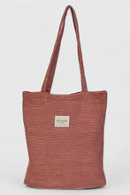 Load image into Gallery viewer, Striped tote bag with a visible brand label on a light gray background