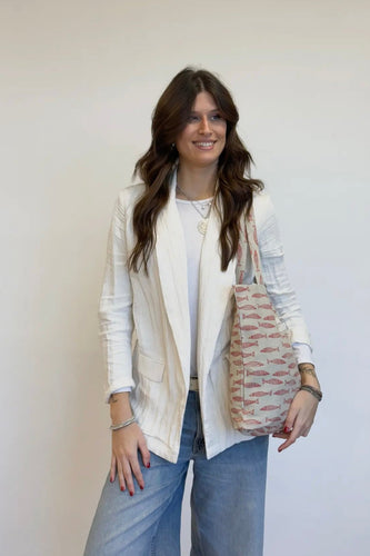 Woman holding a patterned bag against a plain background
