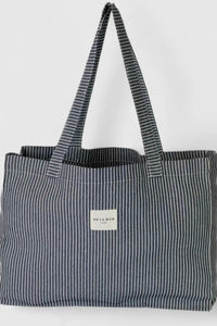 Black and white striped tote bag with a visible brand label on a light gray background
