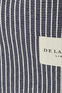 Close-up of a navy and white striped fabric with a label on a navy background