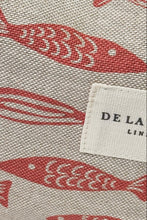 Load image into Gallery viewer, Fabric with red fish pattern and &#39;DE LA&#39; label on a beige background
