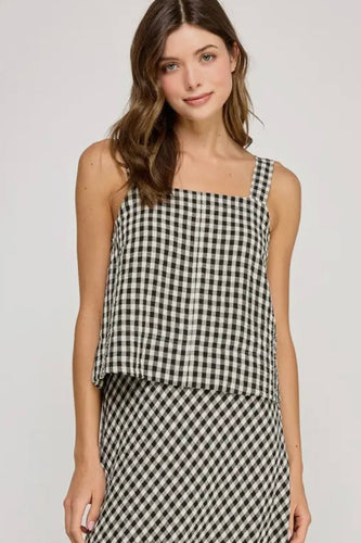 Woman wearing a black and white checkered dress on a plain background