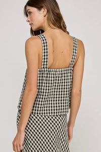 Woman wearing a black and white checkered dress against a plain background
