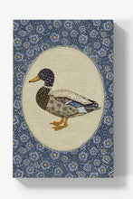 Load image into Gallery viewer, A rectangular wall art print or canvas featuring a stylized mallard duck centered within an oval on a patterned blue background. The duck illustration has a dark speckled head, brown and beige body, and blue-gray wing details.