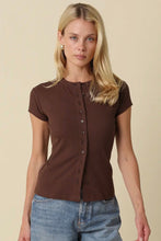 Load image into Gallery viewer, A blonde woman wearing a fitted short-sleeve brown button-front top and blue jeans, standing against a plain beige studio background.
