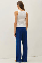 Load image into Gallery viewer, A woman shown from the back wearing a white ribbed tank top and deep blue wide-leg pants against a plain white studio background.