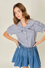 Load image into Gallery viewer, Woman wearing a blue checkered blouse and denim skirt against a plain background