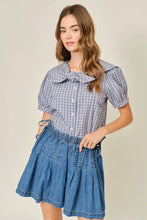 Load image into Gallery viewer, Woman wearing a checkered blouse and denim skirt on a beige background