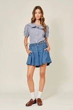 Load image into Gallery viewer, Woman wearing a checkered shirt and denim skirt on a plain background