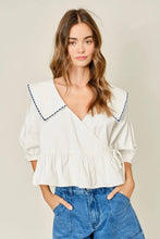 Load image into Gallery viewer, Woman wearing a white blouse with blue trim and blue jeans on a plain background