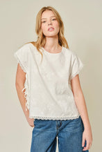 Load image into Gallery viewer, Woman wearing a white lace top and blue jeans on a beige background