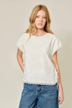 Load image into Gallery viewer, Woman wearing a white lace-trimmed top and blue jeans on a beige background