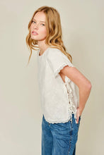 Load image into Gallery viewer, Woman wearing a white lace top and blue jeans against a beige background
