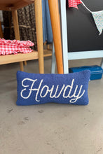 Load image into Gallery viewer, A blue textured throw pillow with the word 'Howdy' embroidered in white script, placed on a concrete floor in a rustic indoor setting.