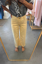 Load image into Gallery viewer, Person wearing yellow pants and a checkered shirt in a clothing store.
