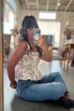 Load image into Gallery viewer, Person taking a mirror selfie wearing a patterned top and blue jeans in an indoor setting.