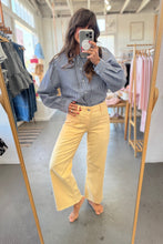 Load image into Gallery viewer, Person taking a mirror selfie wearing a checkered shirt and yellow pants in a clothing store.