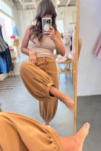 Load image into Gallery viewer, Person wearing beige pants and a light-colored top in a clothing store.
