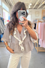 Load image into Gallery viewer, Woman taking a mirror selfie wearing a striped blouse with ruffle details in a clothing store.
