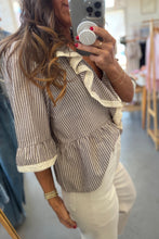 Load image into Gallery viewer, Woman taking a mirror selfie wearing a striped top and beige pants in a clothing store.